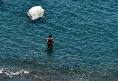 Rear view of shirtless man in sea