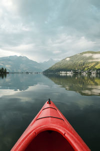 Red boat on lake against sky