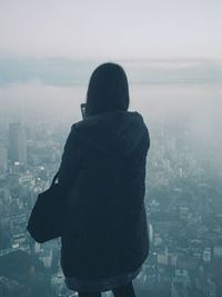 Rear view of woman looking at cityscape