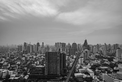 View of cityscape against cloudy sky