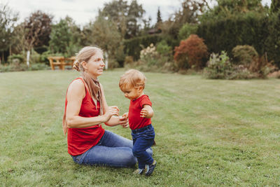 Full length of mother and son playing on field