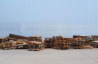 Stack of logs against building