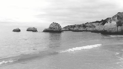 Rocks on sea shore against sky