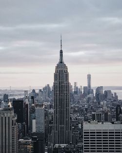 Skyscrapers in city against sky at dusk