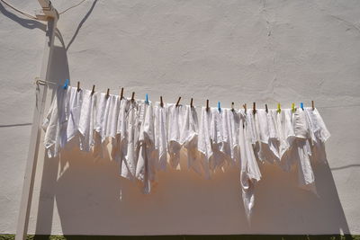 Low angle view of clothesline hanging against wall