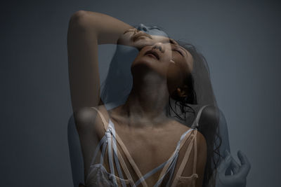 Portrait of young woman against white background