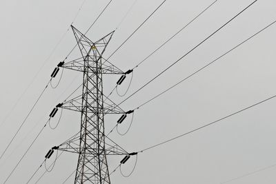 Low angle view of electricity pylon against sky