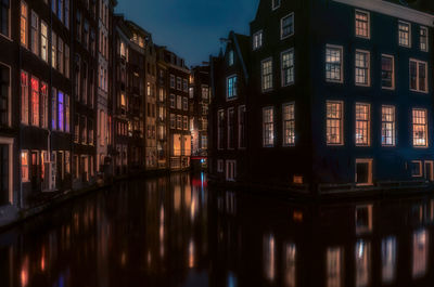 Reflection of buildings on canal at night