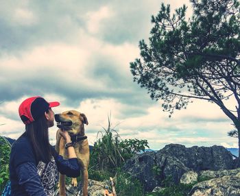 Woman with dog against sky