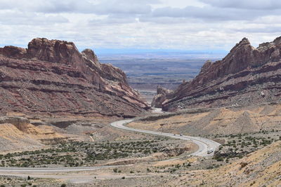 Winding road amidst mountains against sky