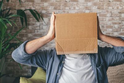 Rear view of man holding cardboard box