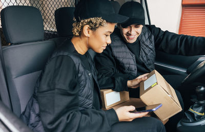 Young couple holding parcel sitting in car