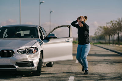 Full length of man photographing car on city street