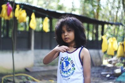 Portrait of girl standing against trees