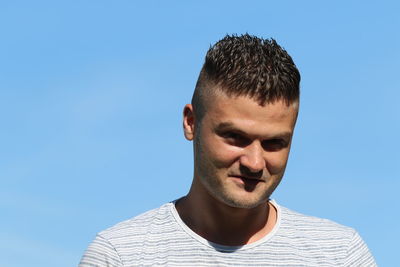 Portrait of young man against clear blue sky