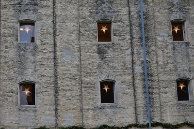 Low angle view of illuminated lamp on building