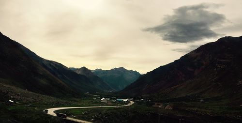 Vehicles on road with mountain range in background