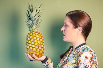 Full length portrait of young woman holding fruit