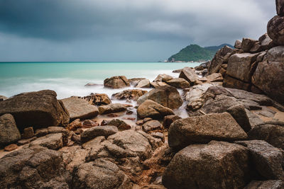 Rocks on beach against sky