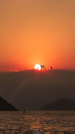 Scenic view of sea against orange sky