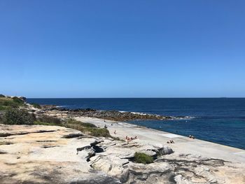 Scenic view of beach against clear blue sky