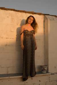 Portrait of woman standing against wall