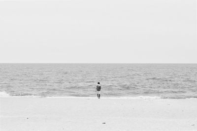 Man on beach against clear sky