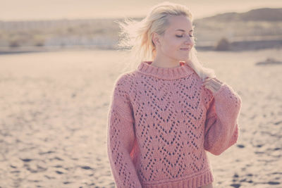 Portrait of a young woman standing on beach