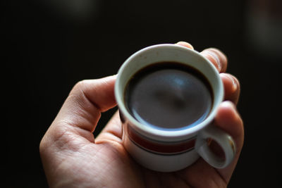 Close-up of hand holding coffee cup