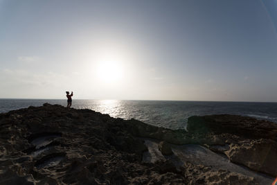 People standing on beach against clear sky