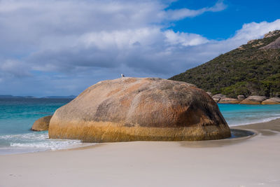 Scenic view of rocks on beach against sky