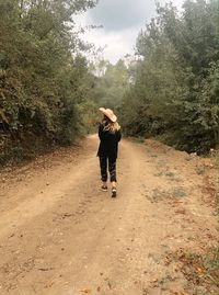 Rear view of woman walking on road