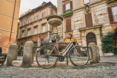 Bicycles parked on street by buildings in city