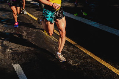 Low section of men running on road