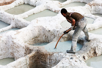 Man working on rock at shore