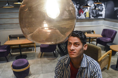 Portrait of young man sitting on table