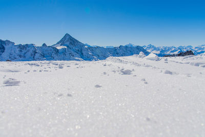 Scenic view of snowcapped mountains against clear blue sky