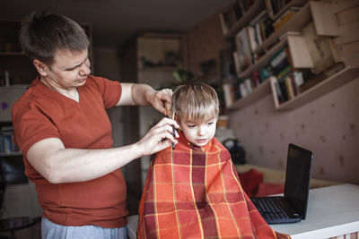 Rear view of boy using mobile phone