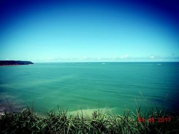 Scenic view of sea against clear blue sky