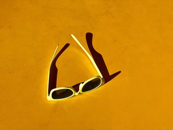 High angle view of sunglasses on yellow background