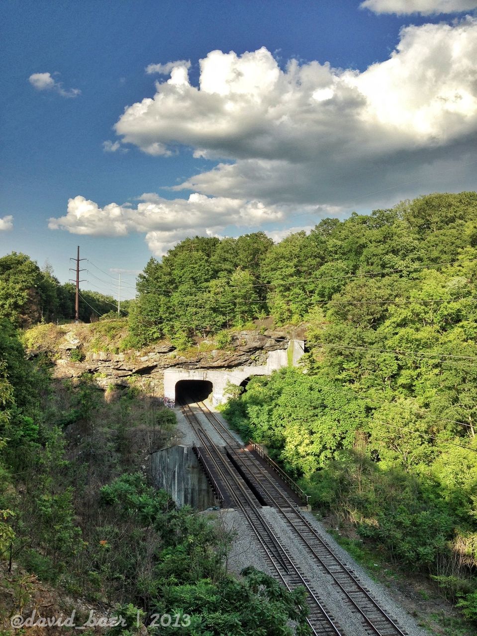 transportation, sky, tree, railroad track, the way forward, rail transportation, cloud - sky, built structure, green color, connection, architecture, high angle view, mountain, day, travel, mode of transport, cloud, diminishing perspective, road, landscape