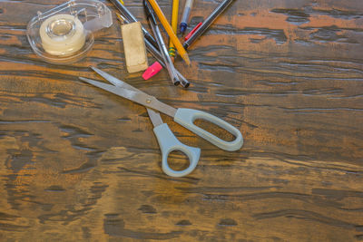 High angle view of school supplies on wooden table