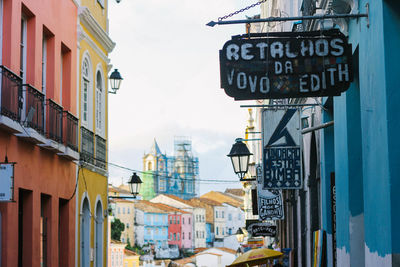 Information sign on street amidst buildings in city