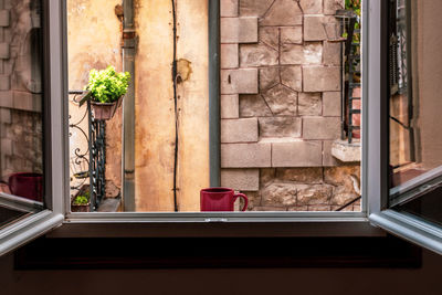 A red cup of coffee on window sill of building