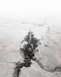 Scenic view of snow covered land and sea against sky