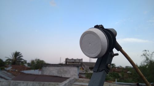 Low angle view of coin-operated binoculars against sky