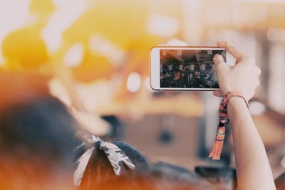 Midsection of woman photographing with mobile phone