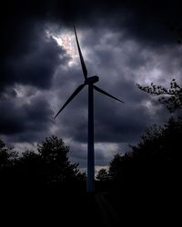 Low angle view of wind turbine against cloudy sky