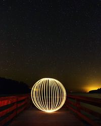 Illuminated light against sky at night