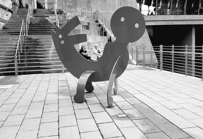 Side view of woman sitting on footpath